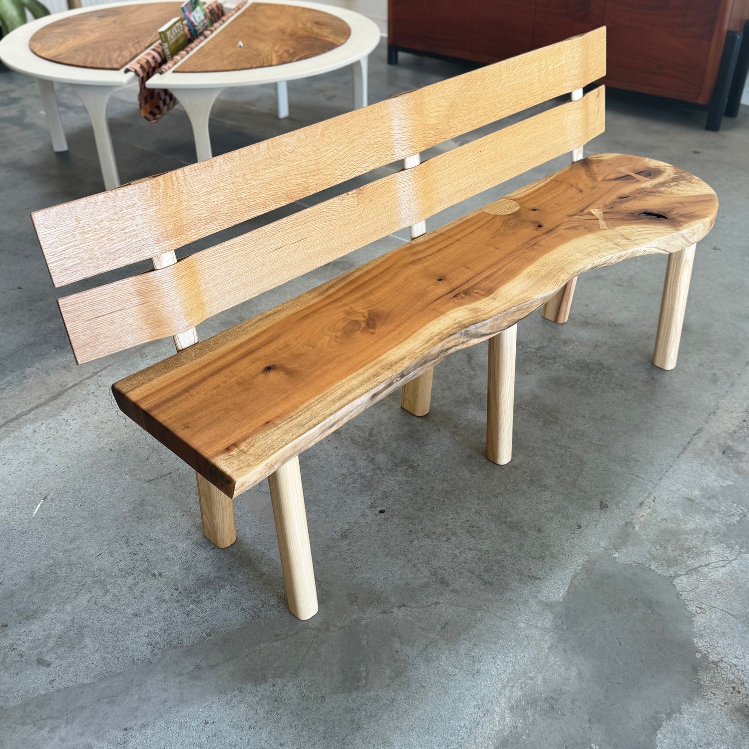 Wooden bench with a natural finish on a concrete floor