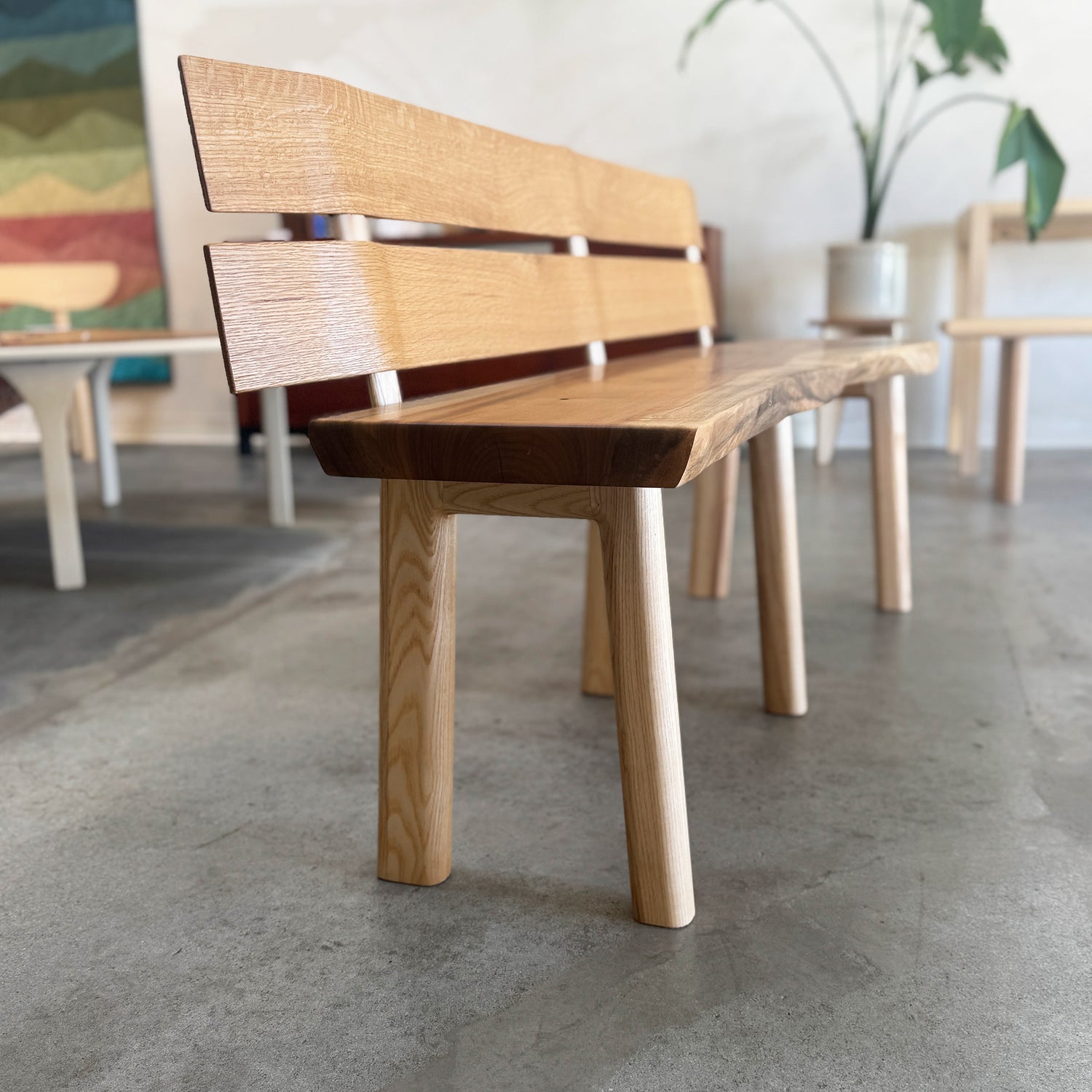 Wooden bench with a white oak slat backrest in an indoor setting