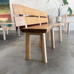 Wooden bench with a white oak slat backrest in an indoor setting