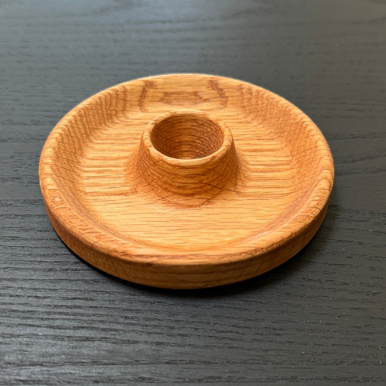 Wooden candle holder on a dark wooden surface