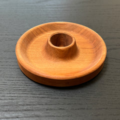 Wooden candle holder on a dark wooden surface
