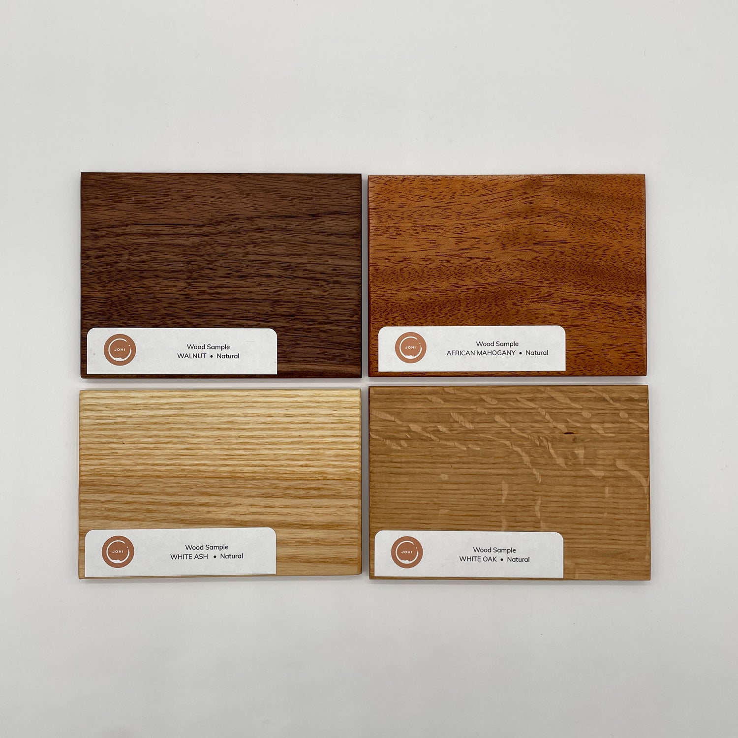 Finish samples of natural Walnut, African Mahogany, White Ash, and White Oak.